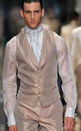 A custom tailored v-neck four button men's vest with a medium gorge, a shawl collar, a satin back, piped lower pockets, and a narrow v bottom.